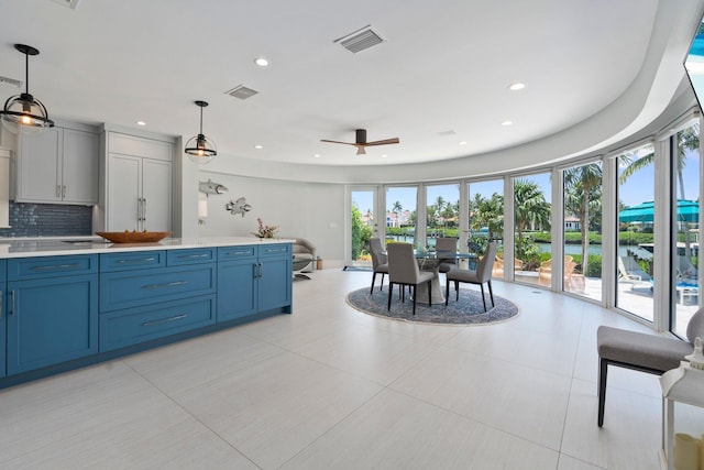 6460 SE Harbor Cir, Stuart, FL 34996 - kitchen with light countertops, blue cabinetry, a ceiling fan, backsplash, and recessed lighting