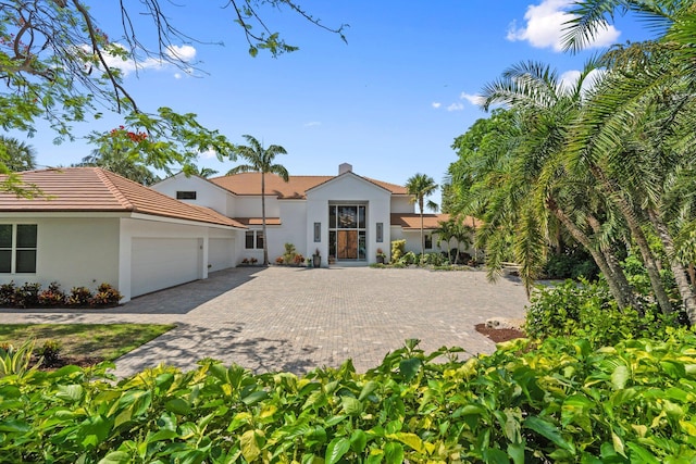 6460 SE Harbor Cir, Stuart, FL 34996 - mediterranean / spanish home featuring stucco siding, an attached garage, decorative driveway, and a tile roof