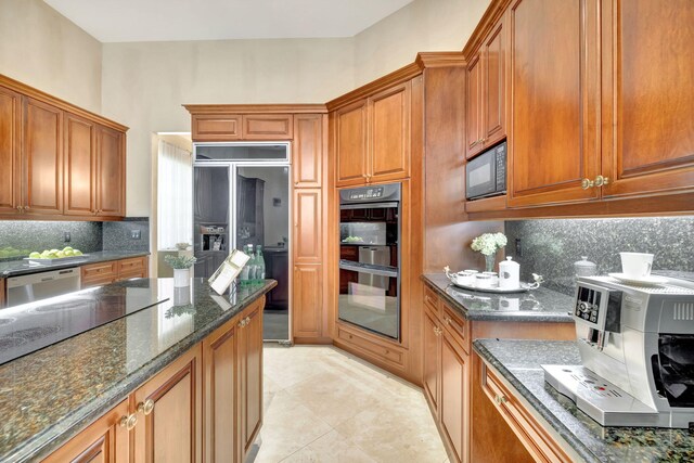 3628 S Ocean Blvd, Highland Beach, FL 33487 - kitchen with black appliances, backsplash, dark stone countertops, and brown cabinetry