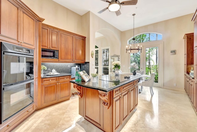 3628 S Ocean Blvd, Highland Beach, FL 33487 - kitchen with black appliances, a towering ceiling, tasteful backsplash, brown cabinets, and arched walkways