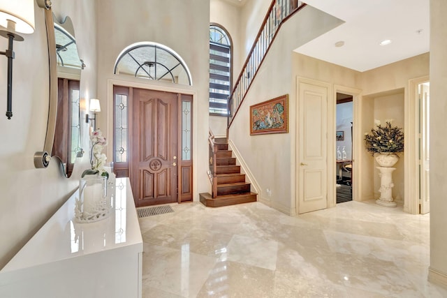 3628 S Ocean Blvd, Highland Beach, FL 33487 - entryway with a towering ceiling, healthy amount of natural light, stairway, marble finish flooring, and baseboards