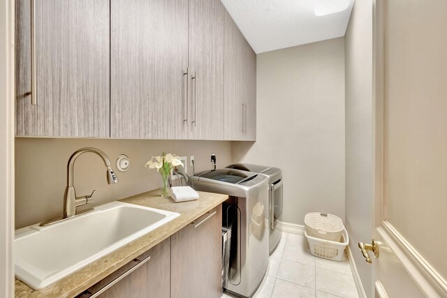 3628 S Ocean Blvd, Highland Beach, FL 33487 - laundry room featuring cabinet space, washer and dryer, light tile patterned flooring, and baseboards