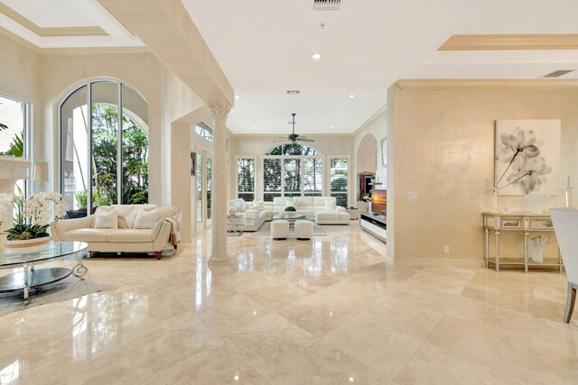 3628 S Ocean Blvd, Highland Beach, FL 33487 - living room featuring a ceiling fan, a fireplace, crown molding, marble tiled flooring, and arched walkways