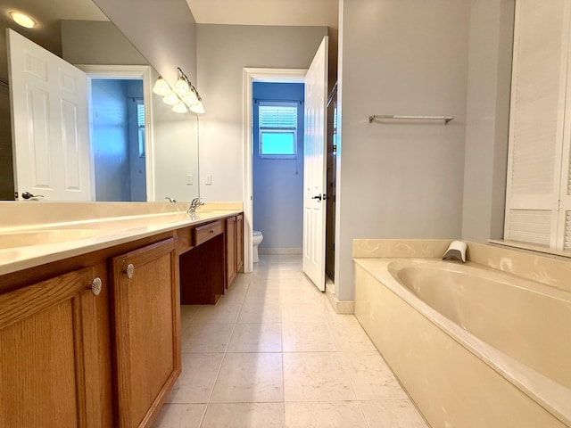855 Marina Del Ray Ln Unit 2, West Palm Beach, FL 33401 - full bathroom featuring double vanity, toilet, a bath, baseboards, and tile patterned floors