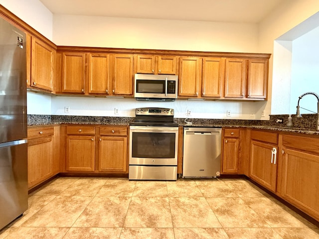 855 Marina Del Ray Ln Unit 2, West Palm Beach, FL 33401 - kitchen with stainless steel appliances, brown cabinets, dark stone counters, and a sink