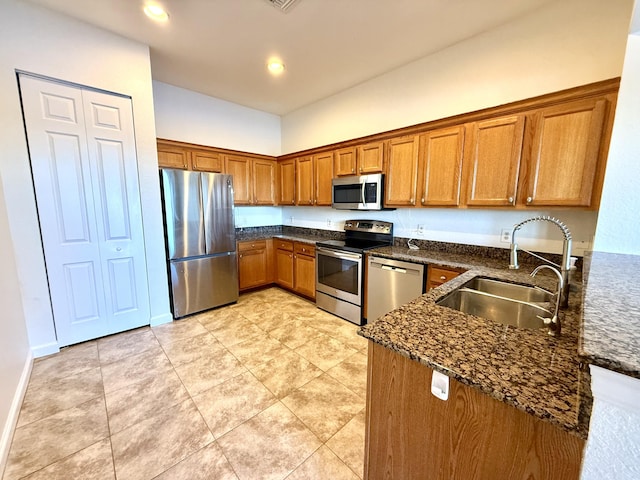 855 Marina Del Ray Ln Unit 2, West Palm Beach, FL 33401 - kitchen featuring stainless steel appliances, brown cabinetry, a sink, dark stone counters, and recessed lighting