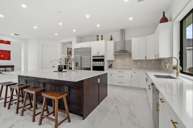 7887 150th Ct N, Palm Beach Gardens, FL 33418 - kitchen featuring appliances with stainless steel finishes, wall chimney range hood, a sink, light marble finish flooring, and tasteful backsplash