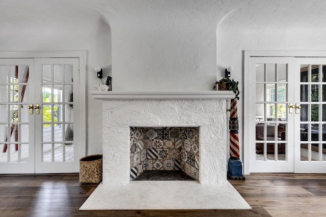 230 Princeton Dr, Lake Worth Beach, FL 33460 - unfurnished living room featuring french doors, wood finished floors, a fireplace, and a textured wall