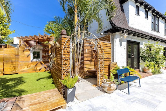 230 Princeton Dr, Lake Worth Beach, FL 33460 - doorway to property with french doors, a pergola, stucco siding, roof with shingles, and a patio area