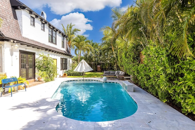 230 Princeton Dr, Lake Worth Beach, FL 33460 - swimming pool with french doors, outdoor lounge area, and a patio area