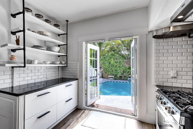 230 Princeton Dr, Lake Worth Beach, FL 33460 - kitchen with dark countertops, open shelves, tasteful backsplash, and white cabinets