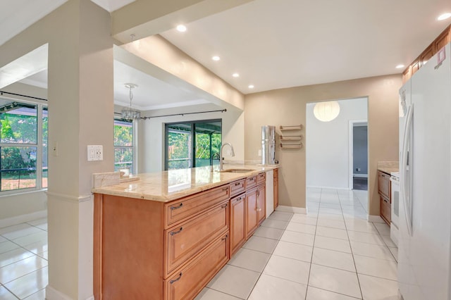 1197 Belmore Ter, Wellington, FL 33414 - kitchen with freestanding refrigerator, light stone countertops, a sink, light tile patterned flooring, and recessed lighting