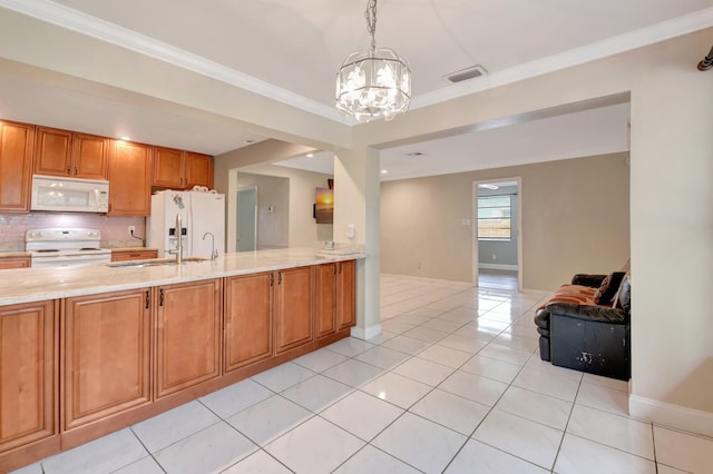 1197 Belmore Ter, Wellington, FL 33414 - kitchen with white appliances, a chandelier, brown cabinetry, a sink, and light tile patterned floors