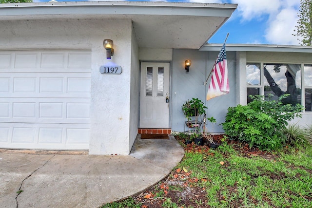 1197 Belmore Ter, Wellington, FL 33414 - view of exterior entry featuring an attached garage and stucco siding