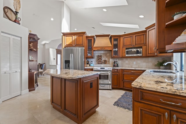 3819 N Ocean Dr, Singer Island, FL 33404 - kitchen featuring appliances with stainless steel finishes, open shelves, custom range hood, a skylight, and high vaulted ceiling
