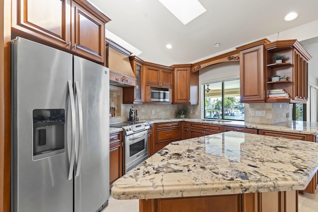 3819 N Ocean Dr, Singer Island, FL 33404 - kitchen with appliances with stainless steel finishes, a sink, a skylight, a kitchen island, and light stone countertops
