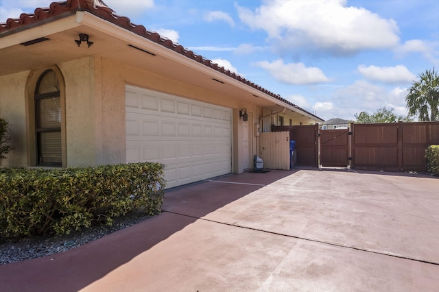3819 N Ocean Dr, Singer Island, FL 33404 - view of property exterior featuring a gate, driveway, a tiled roof, and stucco siding