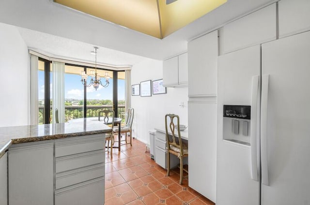1900 Consulate Pl Unit 402, West Palm Beach, FL 33401 - kitchen with refrigerator with ice dispenser, a chandelier, tile patterned flooring, white cabinetry, and pendant lighting
