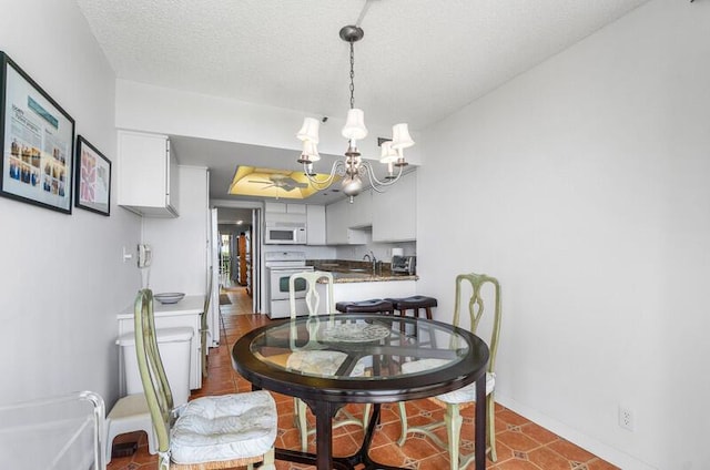 1900 Consulate Pl Unit 402, West Palm Beach, FL 33401 - dining room featuring a chandelier, baseboards, and a textured ceiling