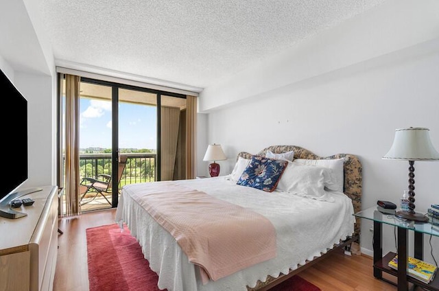 1900 Consulate Pl Unit 402, West Palm Beach, FL 33401 - bedroom with access to outside, a textured ceiling, wood finished floors, and a wall of windows