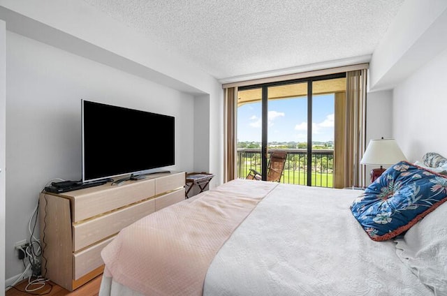 1900 Consulate Pl Unit 402, West Palm Beach, FL 33401 - bedroom featuring access to outside, a textured ceiling, and wood finished floors