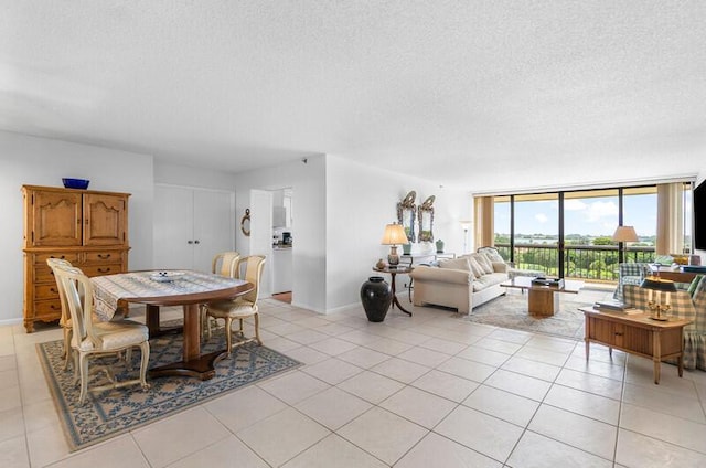 1900 Consulate Pl Unit 402, West Palm Beach, FL 33401 - dining room with a textured ceiling, light tile patterned flooring, a wall of windows, and baseboards