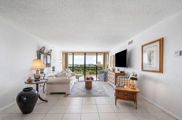 1900 Consulate Pl Unit 402, West Palm Beach, FL 33401 - living area featuring a textured ceiling, light tile patterned flooring, and baseboards