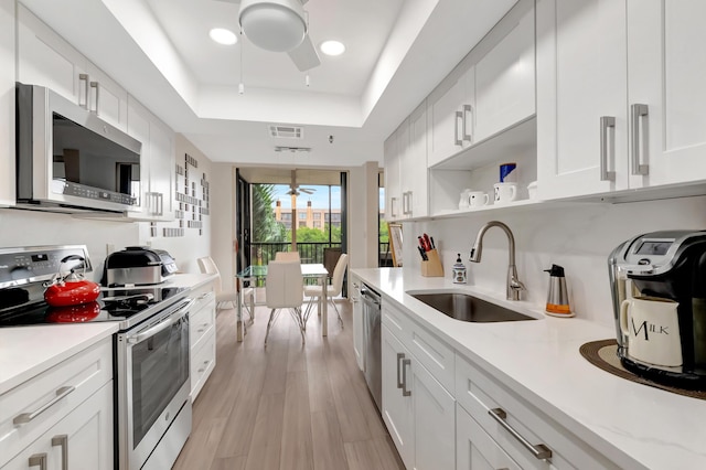 20100 Boca W Dr Unit 163, Boca Raton, FL 33434 - kitchen featuring appliances with stainless steel finishes, a tray ceiling, ceiling fan, a sink, and open shelves