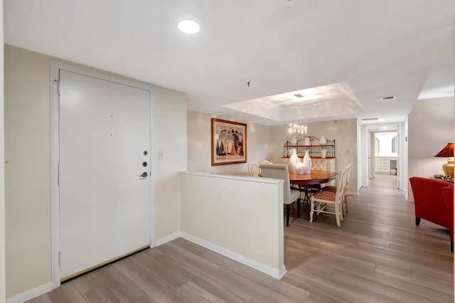 20100 Boca W Dr Unit 163, Boca Raton, FL 33434 - entryway featuring a chandelier, light wood-type flooring, baseboards, and a tray ceiling