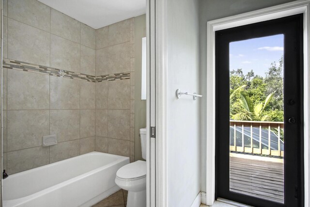 880 NE Stokes Ter, Jensen Beach, FL 34957 - full bath featuring toilet, plenty of natural light, tile patterned floors, and bathing tub / shower combination