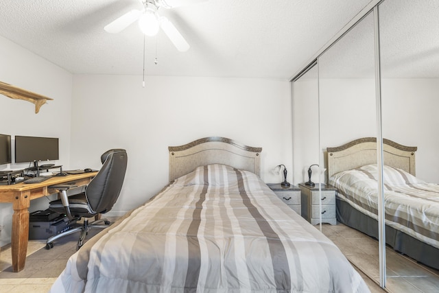 2513 25th Ln, Palm Beach Gardens, FL 33418 - bedroom featuring a textured ceiling, an office area, a ceiling fan, light tile patterned floors, and a closet