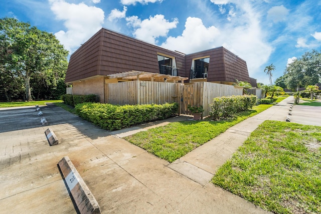 2513 25th Ln, Palm Beach Gardens, FL 33418 - view of side of home with mansard roof and brick siding