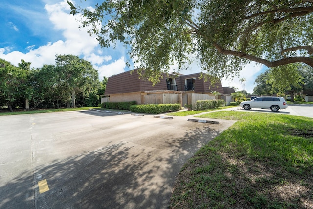2513 25th Ln, Palm Beach Gardens, FL 33418 - view of side of property with uncovered parking and mansard roof