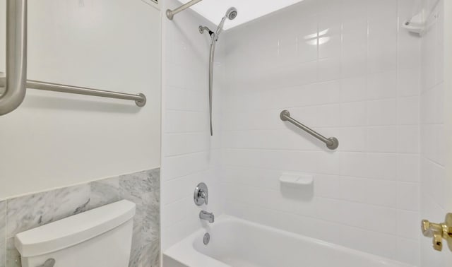 328 N Ocean Blvd Unit 404, Pompano Beach, FL 33062 - bathroom with toilet, shower / bathtub combination, a wainscoted wall, and tile walls