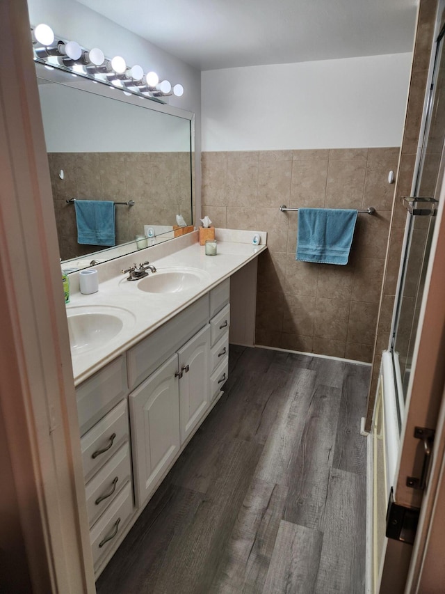 302 Wellington Unit B, West Palm Beach, FL 33417 - bathroom featuring wood finished floors, double vanity, and tile walls