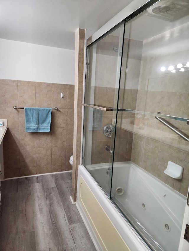 302 Wellington Unit B, West Palm Beach, FL 33417 - bathroom with wood finished floors, tile walls, toilet, a combined bath / shower with jetted tub, and vanity