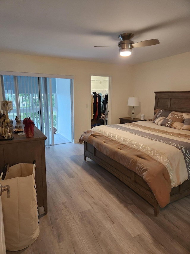 302 Wellington Unit B, West Palm Beach, FL 33417 - bedroom with wood finished floors, access to exterior, a walk in closet, and ceiling fan