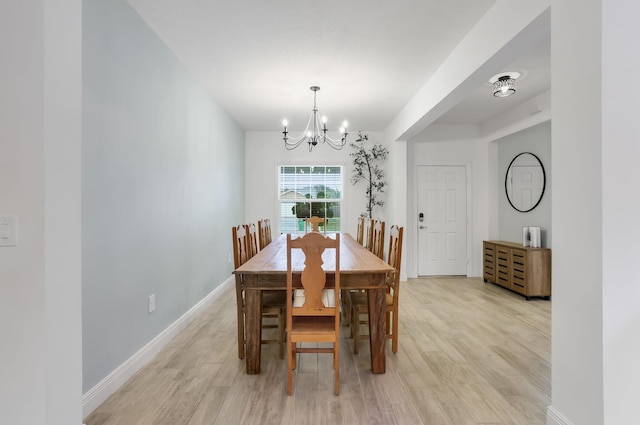 3974 SW Jarmer Rd, Port Saint Lucie, FL 34953 - dining room with a chandelier, light wood finished floors, and baseboards