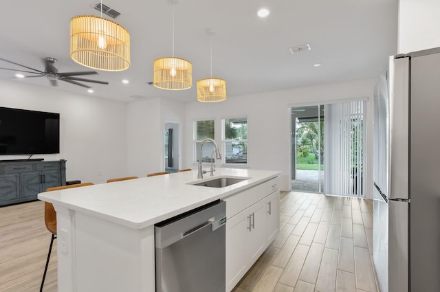 3974 SW Jarmer Rd, Port Saint Lucie, FL 34953 - kitchen with appliances with stainless steel finishes, a sink, open floor plan, white cabinetry, and light countertops