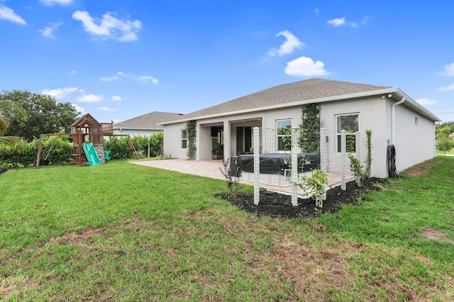 3974 SW Jarmer Rd, Port Saint Lucie, FL 34953 - back of property featuring a patio, a playground, a yard, stucco siding, and roof with shingles