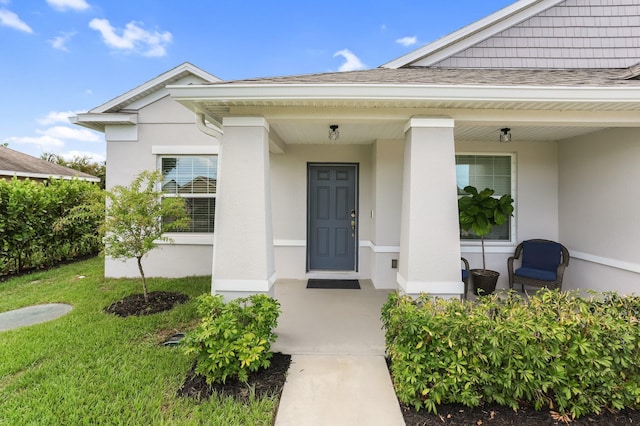 3974 SW Jarmer Rd, Port Saint Lucie, FL 34953 - property entrance with stucco siding, roof with shingles, covered porch, and a lawn