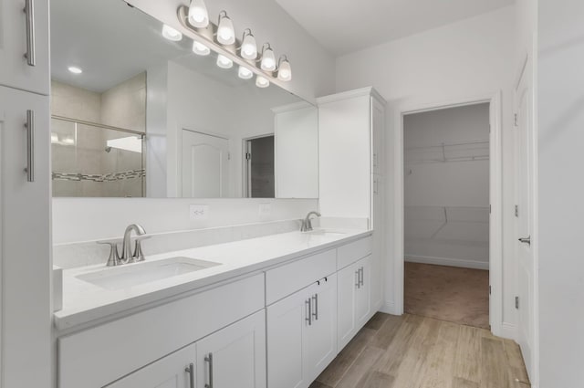 3974 SW Jarmer Rd, Port Saint Lucie, FL 34953 - full bath with a spacious closet, wood finished floors, double vanity, and a shower stall