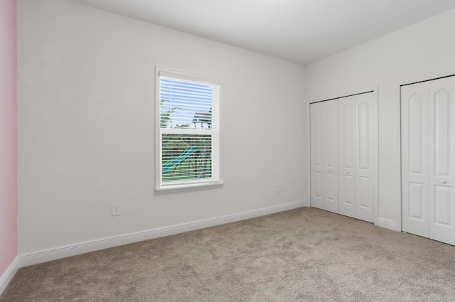 3974 SW Jarmer Rd, Port Saint Lucie, FL 34953 - unfurnished bedroom featuring carpet, multiple closets, and baseboards