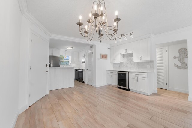 109 Wettaw Ln Unit 103, North Palm Beach, FL 33408 - kitchen featuring beverage cooler, appliances with stainless steel finishes, a chandelier, light countertops, and ornamental molding