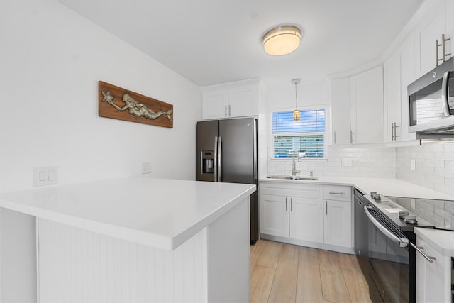 109 Wettaw Ln Unit 103, North Palm Beach, FL 33408 - kitchen featuring a sink, stainless steel appliances, a peninsula, tasteful backsplash, and light countertops
