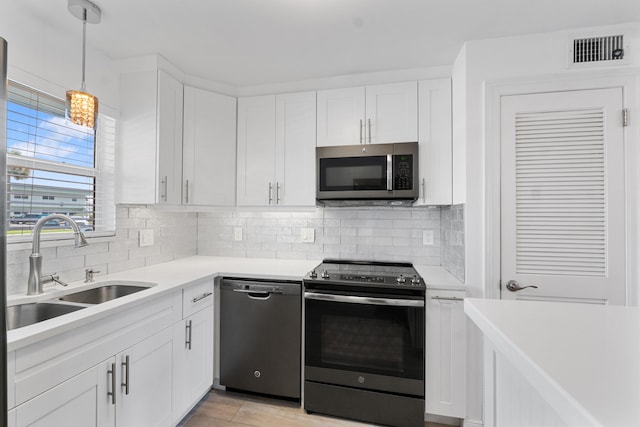 109 Wettaw Ln Unit 103, North Palm Beach, FL 33408 - kitchen with stainless steel appliances, a sink, light countertops, and white cabinetry