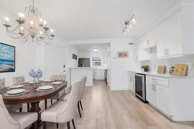 109 Wettaw Ln Unit 103, North Palm Beach, FL 33408 - dining room with wine cooler, a chandelier, light wood finished floors, and crown molding