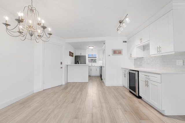 109 Wettaw Ln Unit 103, North Palm Beach, FL 33408 - kitchen featuring stainless steel fridge, wine cooler, decorative backsplash, a chandelier, and light countertops