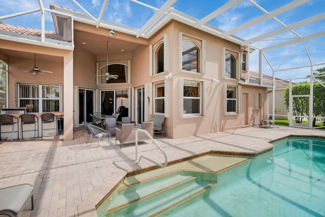 12373 Cascades Pointe Dr, Boca Raton, FL 33428 - rear view of house with stucco siding, a patio, glass enclosure, a ceiling fan, and an outdoor pool