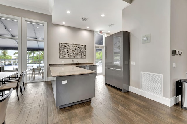 12373 Cascades Pointe Dr, Boca Raton, FL 33428 - kitchen featuring baseboards, dark wood-style flooring, light stone counters, recessed lighting, and a peninsula